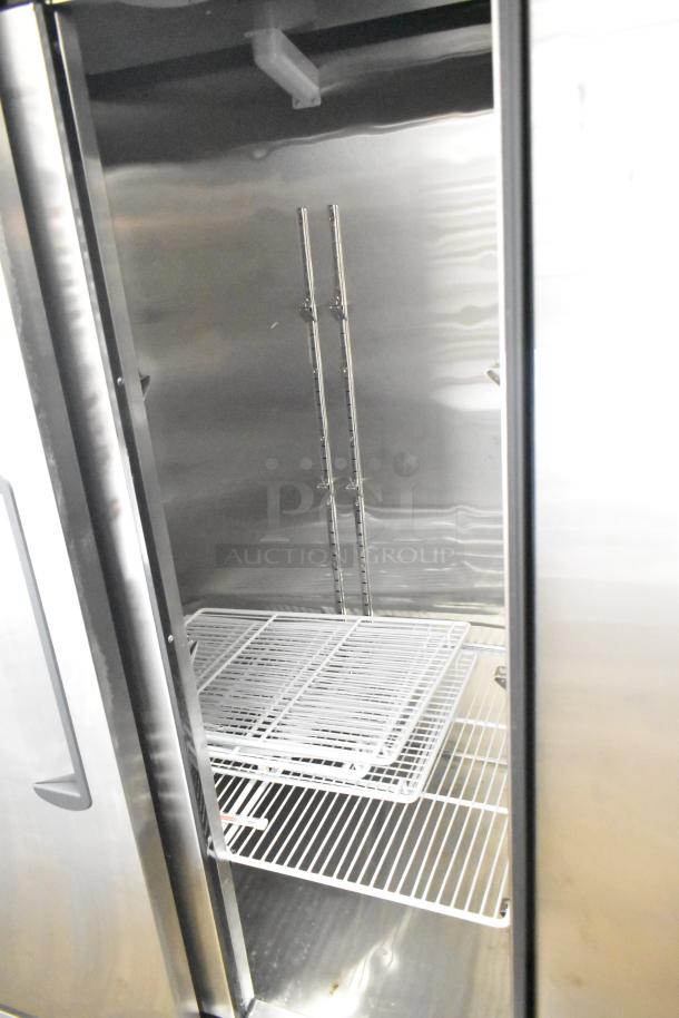 2021 Migali C-2RB-35-HC commercial 2-door reach-in cooler interior, features metal shelves, 115 volts, single phase.
