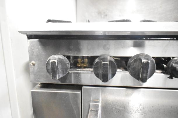 CRC commercial gas range, 6 burners, oven, shelf, backsplash; used condition, visible wear on knobs and surfaces.