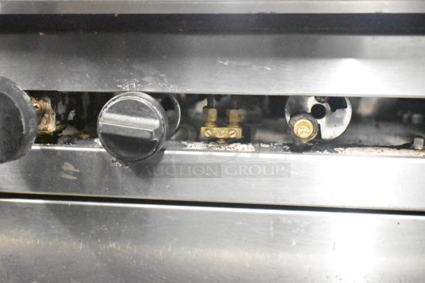 CRC 6-burner commercial range control panel, showing various metal control knobs on a stainless steel finish.