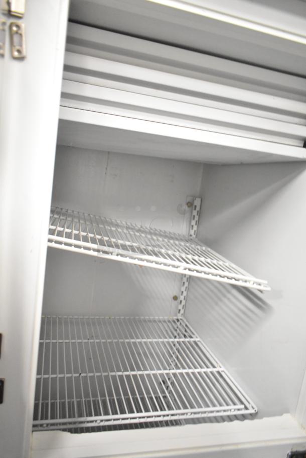 Kelvinator T5CHSGHP-4, 4 half-size door reach-in cooler, 115/208-230V, 1 phase, wire shelves, clean interior.
