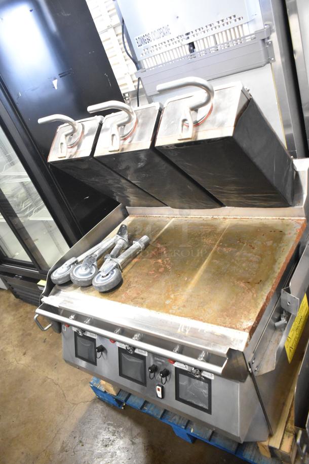 Commercial electric flat top griddle with 3-section panini clam shell, visible rust on surface, includes four caster wheels.