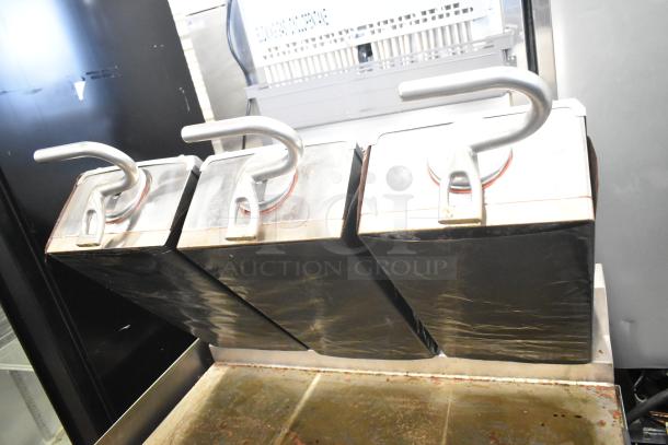 Commercial electric flat top griddle with three-section panini-style clam shell, stainless steel handles, used condition.