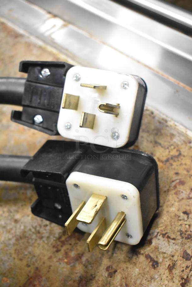 Commercial electric flat top griddle plug, showing two power connectors. Griddle features 3-section panini-style clam shell.