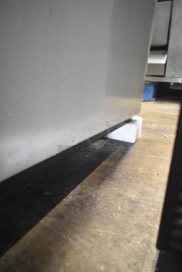 2022 True T-35-HC commercial 2-door reach-in cooler on casters. Visible bottom corner; details obscured.