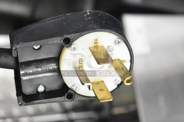 Electrical plug component of a 2021 Taylor 359-33 soft serve ice cream machine, showing prongs and casing detail.