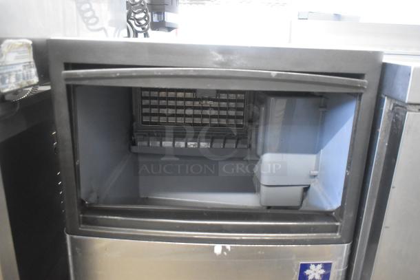 Manitowoc QM45A stainless steel undercounter ice machine, 115 volts, 1 phase, interior view, minor wear visible.