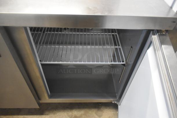 Avantco 178AWT48FHC stainless steel commercial 2 door work top freezer, shown open, on casters, 115V, 1 phase.