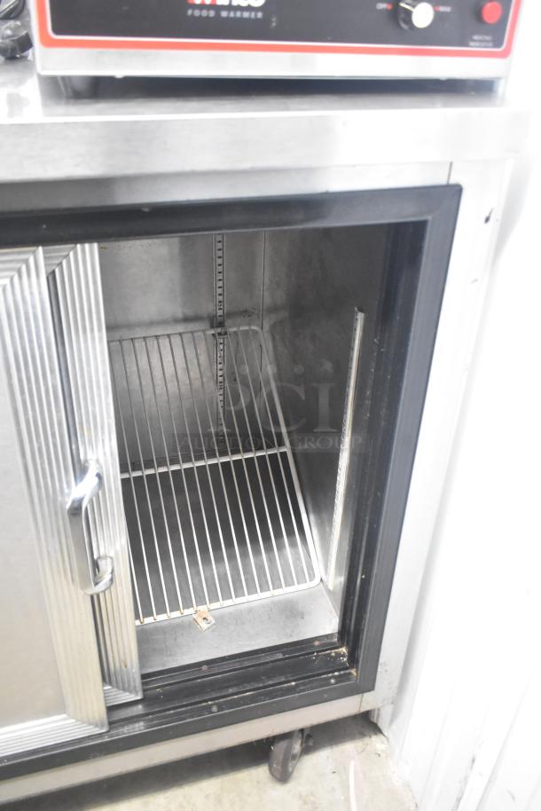 Commercial 2 Door Back Bar Cooler with open door, metal shelves, stainless steel finish, on commercial casters.