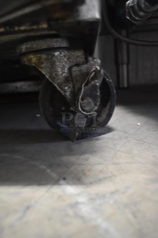 Worn caster of Continental KC24-SS commercial kegerator, showing rust and wear, attached to metal base.