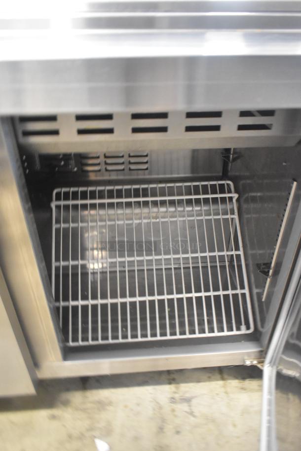 Avantco 178SSPT48MHC stainless steel sandwich and salad prep table with open door showing interior shelf and vent.