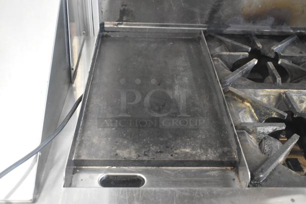 Migali C-RO4B-12GL-NG commercial 4 burner range with griddle, standard oven, on commercial casters. Used condition.