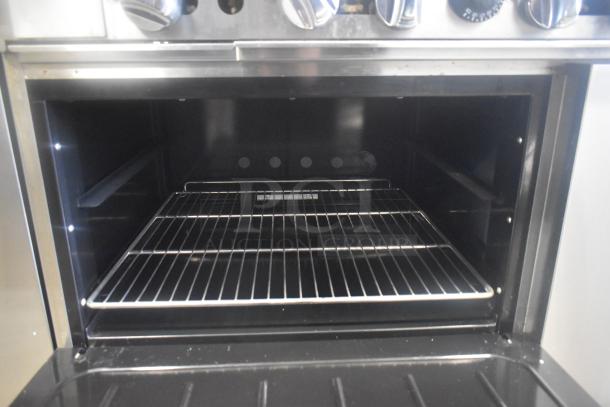 Migali C-RO4B-12GL-NG Commercial 4 Burner Range with Griddle, open oven view, stainless steel, commercial casters.