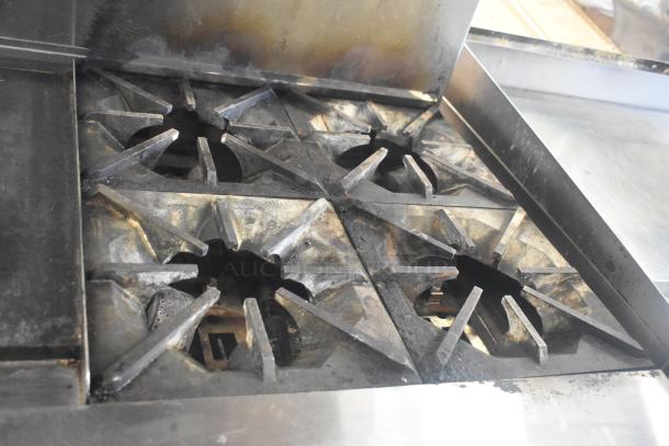 Migali C-RO4B-12GL-NG commercial 4 burner range, natural gas, with griddle and oven, on casters. Used condition.