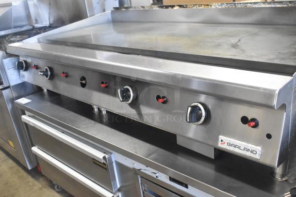 Garland GTGG60 commercial countertop natural gas griddle, stainless steel, flat top, multiple control knobs, branded label.