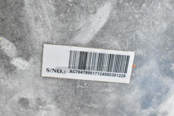 Adcraft FW-1500W/C food warmer tag showing serial number AC704780617124080301228 on metallic surface.