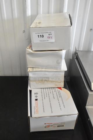 Four new, slightly damaged boxes of VLED-EL90 Exit Signs by Extronix. Contains auction label and branding.