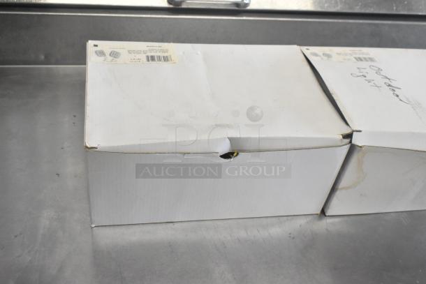 Four new scratch-and-dent items in boxes, including VLED-EL90 exit sign, boxes show slight damage.