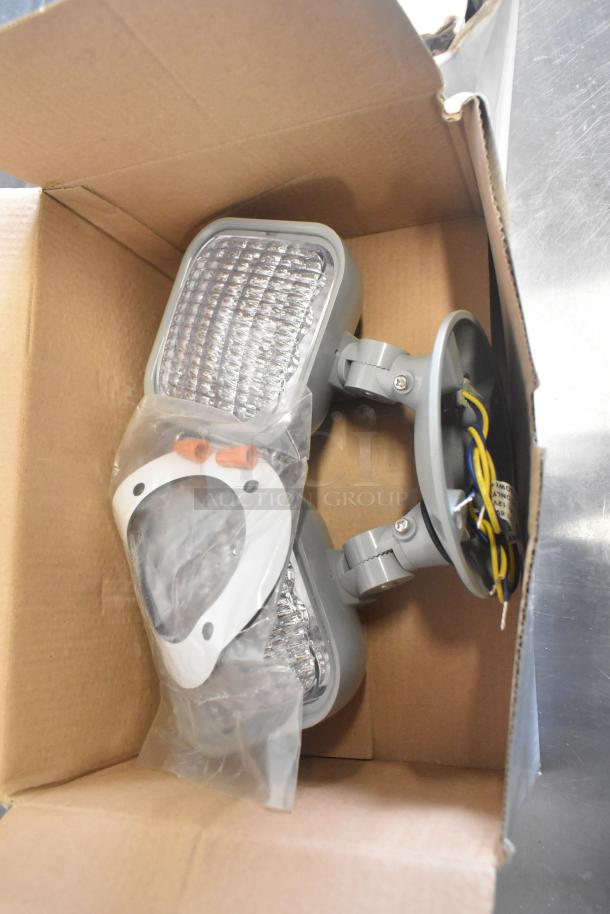 Four brand new VLED-EL90 exit sign units, scratch and dent, in open box with installation accessories.