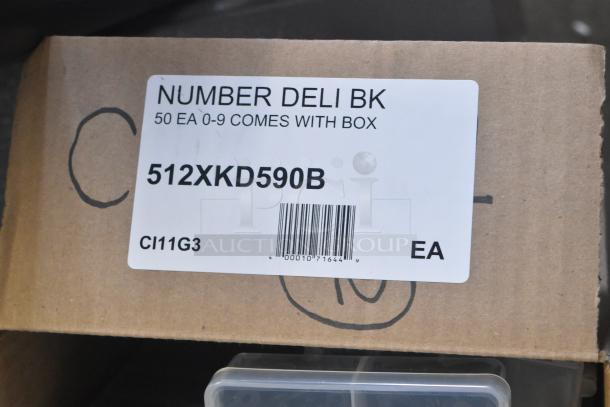 Brand new scratch and dent lot with 512XKD590B 3/4" black plastic deli tag numbers 0-9, boxed label, plastic case visible.