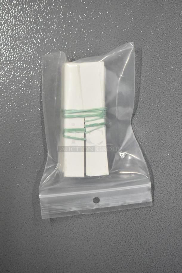 Brand new deli tag inserts in sealed plastic bag, tied with green bands. Includes blank name inserts, numbers 0-9.