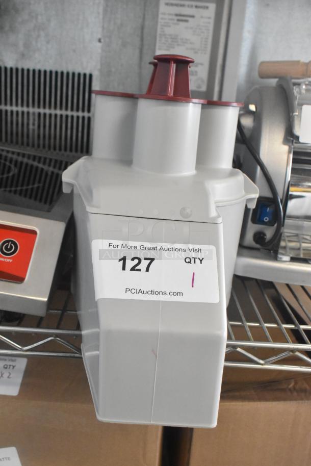 Brand new gray poly continuous feed head attachment for food processor; slight scratches, item tag "127," on auction shelf.