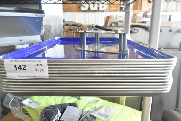 Stack of 13 new aluminum bun pans, 18"x26", 19 gauge, with quantity tag, auction info, and plastic-covered Robot Coupe piece.