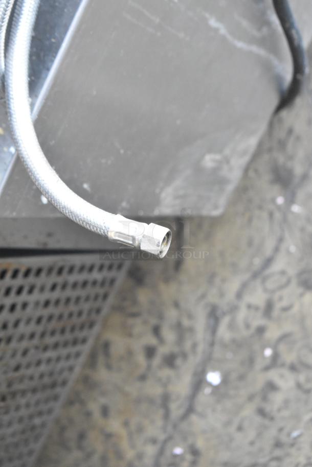 Close-up of a metallic gas connector for a 2016 Cleveland 24CGA10.2 steam cabinet, showing attachment detail.