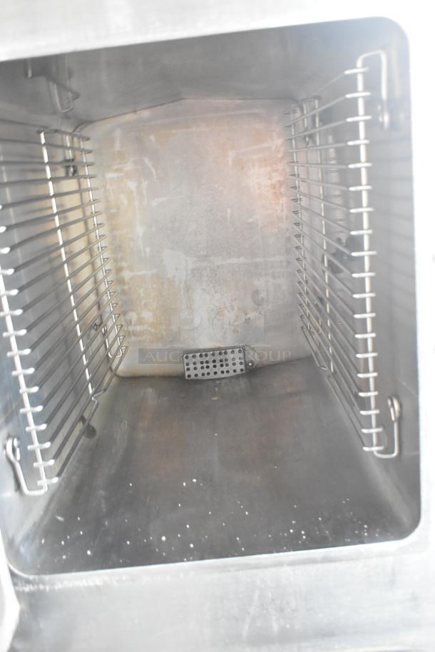 2016 Cleveland 24CGA10.2 steam cabinet interior, showing stainless steel racks and chamber condition. 72,000 BTU, natural gas.