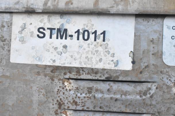 Rusted Cleveland Steam Cabinet label with code "STM-1011" on stainless steel surface, model 24CGA10.2.