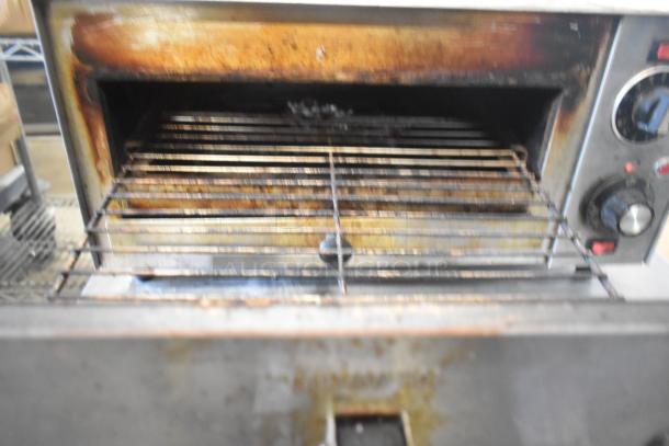 Star P012 countertop electric pizza oven, visible wear, 120 volts, 1 phase. Features temperature controls and metal grill.