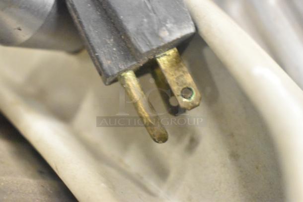 Close-up of a power plug for a Hobart countertop meat slicer, 115 volts, 1 phase, showing slight wear on prongs.