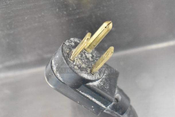 Alt text: Close-up of a True TPP-60 Commercial Pizza Prep Table plug for 115 volts, showing metal prongs.