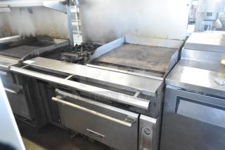 Vulcan commercial gas range with 4 burners, flat top griddle, oven, and casters. Missing 2 grates.