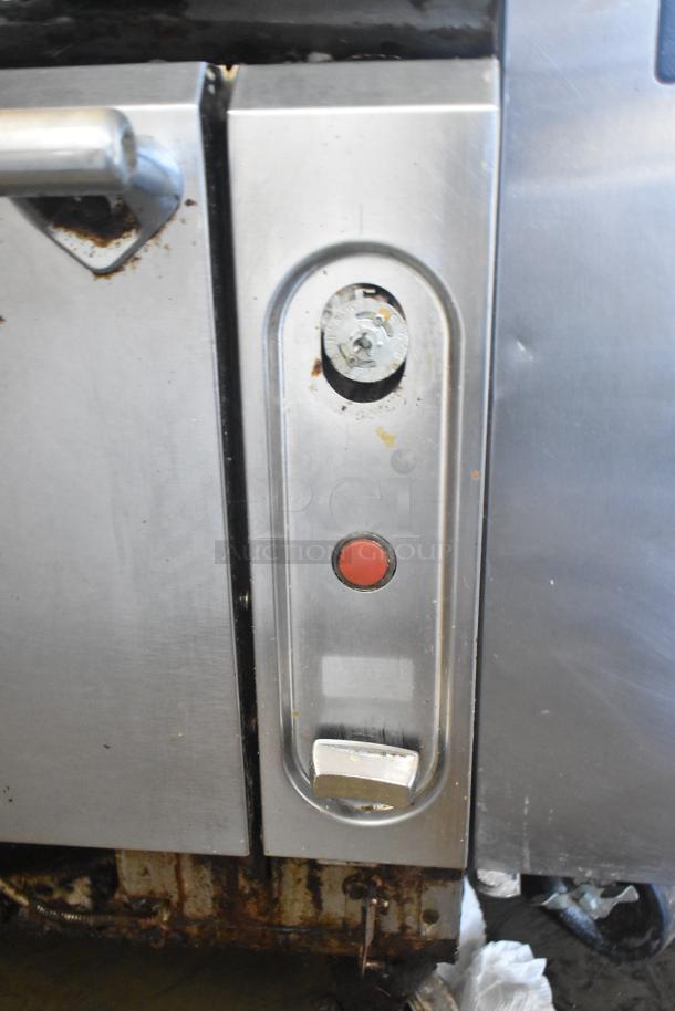 Vulcan commercial gas range with 4 burners, flat top griddle, oven, and casters. Missing 2 grates. Signs of wear.