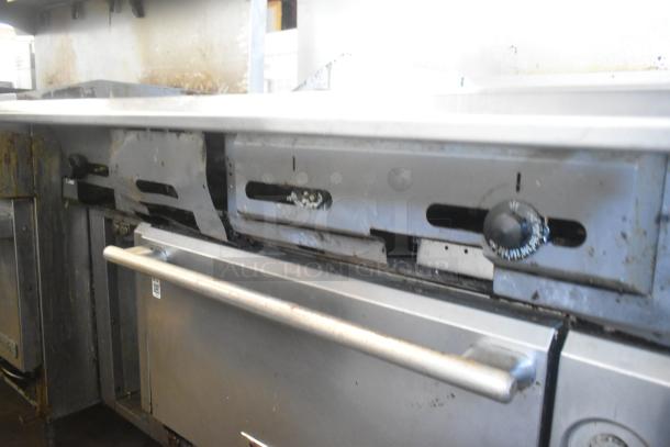 Vulcan commercial gas range with 4 burners, flat top griddle, oven, on casters. Missing 2 grates. Used condition.