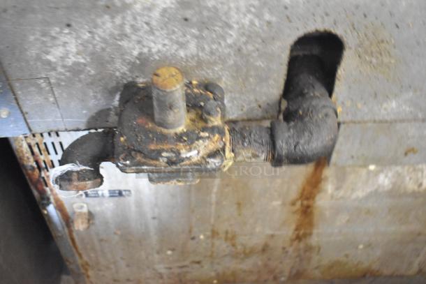 Vulcan commercial gas-powered range with 4 burners, flat top griddle, and oven. Missing 2 grates. Mounted on commercial casters.