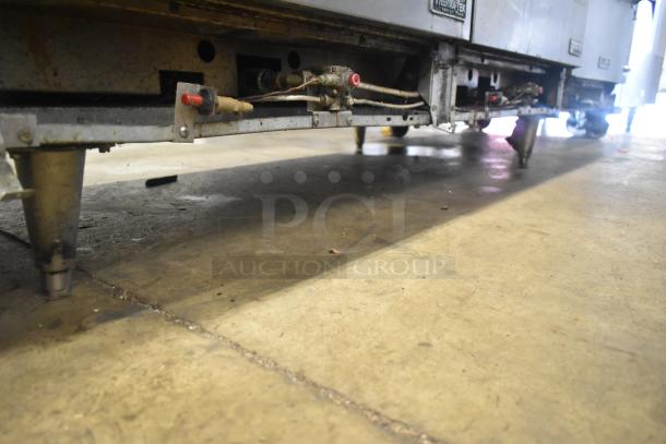 ThermaTek commercial gas range, 6 burners, flat top griddle, 2 ovens. Visible underside mechanics, legs, and wear marks.