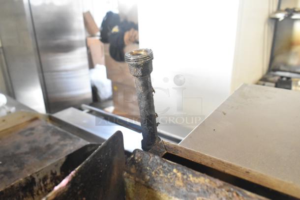 ThermaTek 6-burner gas range with flat top griddle and 2 ovens, showing signs of wear. Ideal for commercial kitchens.