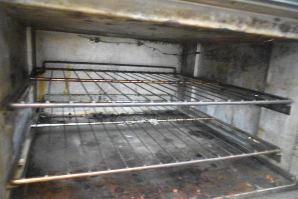 ThermaTek commercial oven interior, featuring racks with signs of use, part of a 6-burner range with griddle.