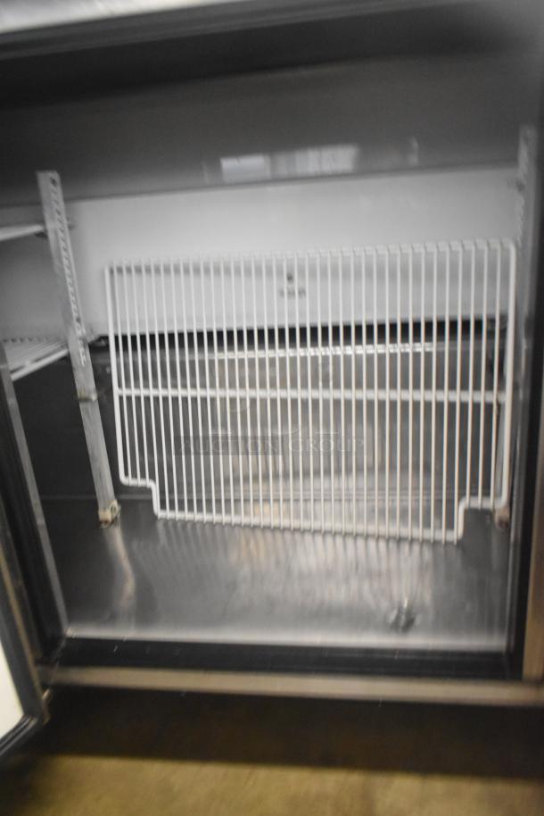 True TWT-72 commercial 3-door work top cooler, stainless steel interior, on casters, 115 volts, model tag visible.