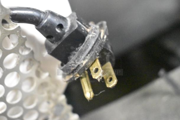 Close-up of electrical plug for the True TWT-72 Commercial 3 Door Work Top Cooler, showing prongs and black casing.