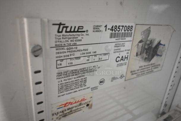True GDM-12 commercial cooler label showing model, voltage 115, 1 phase, cabinet serial number 1-4857088, made in USA.