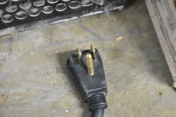Power plug of a True GDM-12 cooler on a concrete floor, showing slight wear. 115 Volt, 1 Phase.