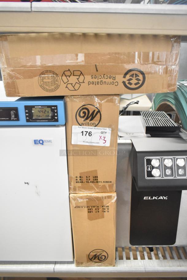 Three new Wilton 191002412 12-compartment non-stick brownie pans in boxes. Dimensions: 2.5" x 2.5" x 1.5". Some box damage.