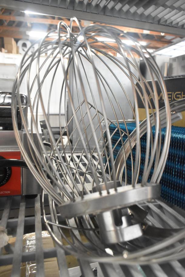 Brand new stainless steel whisk attachment on a shelf. Included with bowl guard. Scratch and dent condition.
