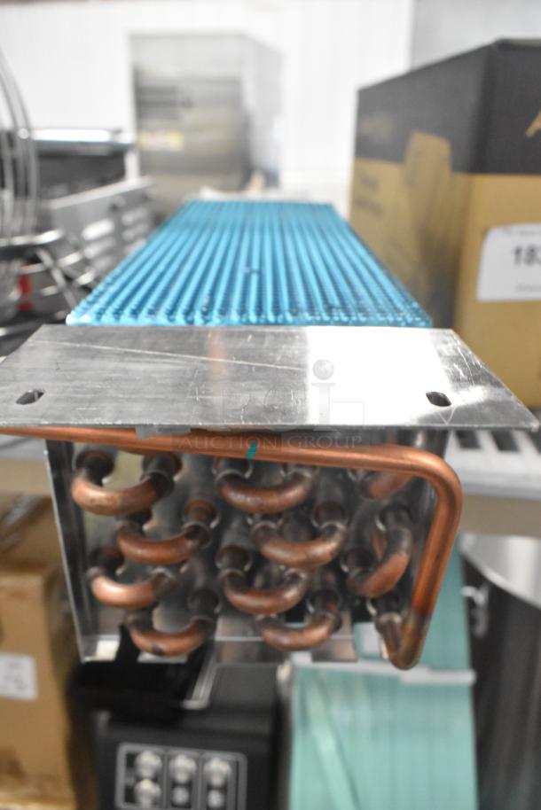 Brand new evaporator coil with copper tubing, showing minor scratches. Ideal for air conditioning systems.