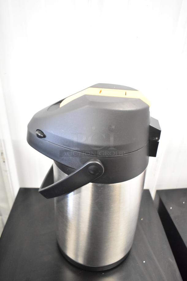 Brand new Acopa Air Pot with minor scratches and dents, stainless steel body, black handle and lid, ideal for beverages.