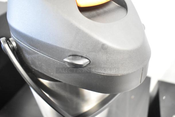 BRAND NEW Acopa Air Pot with scratch and dent. Black lid, silver body. Handle and spout visible. Suitable for hot beverages.