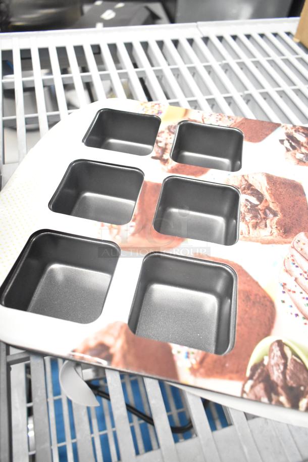 Brand new Wilton 12-compartment non-stick steel brownie pan with 2.5" x 2.5" x 1.5" cavities, minor cosmetic flaws.