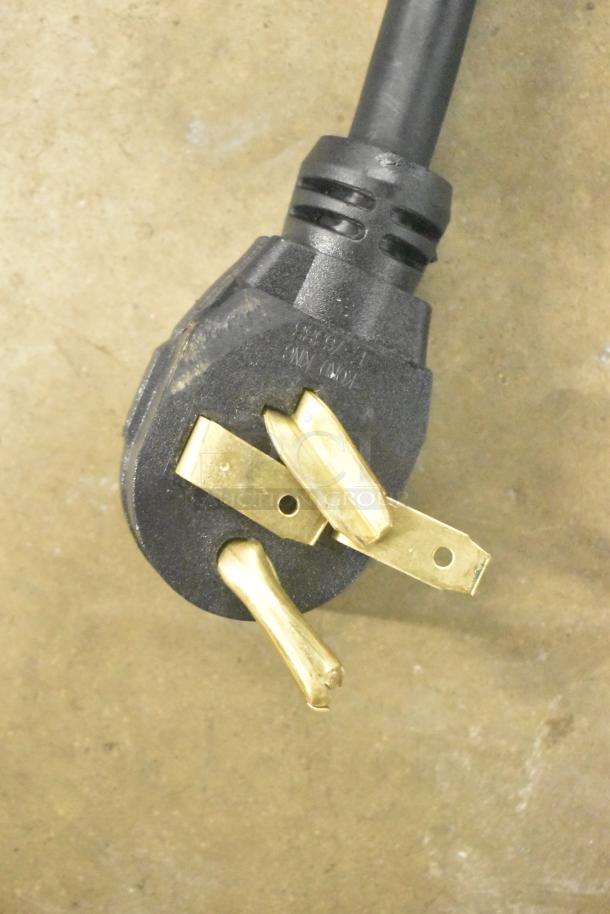 Black and gold electric plug for QNC GFII Quik N Crispy Fryer, 208/240 Volts, 1 Phase, on beige surface.
